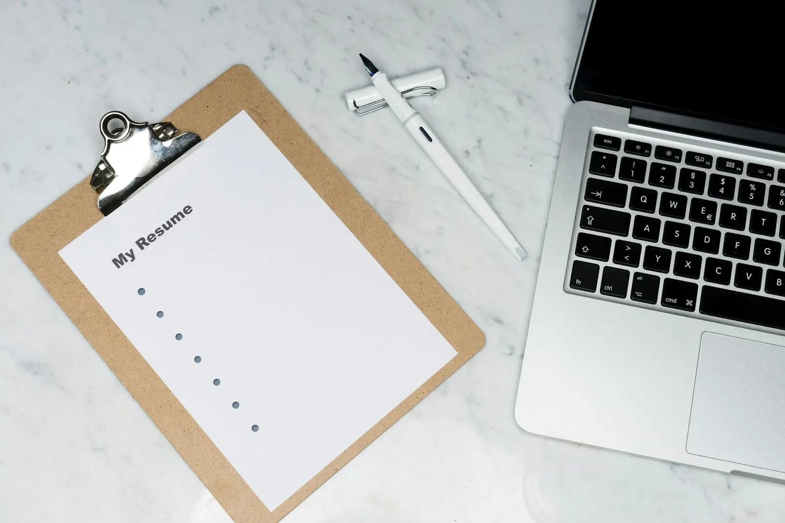 A workspace with notes, a clipboard and a laptop