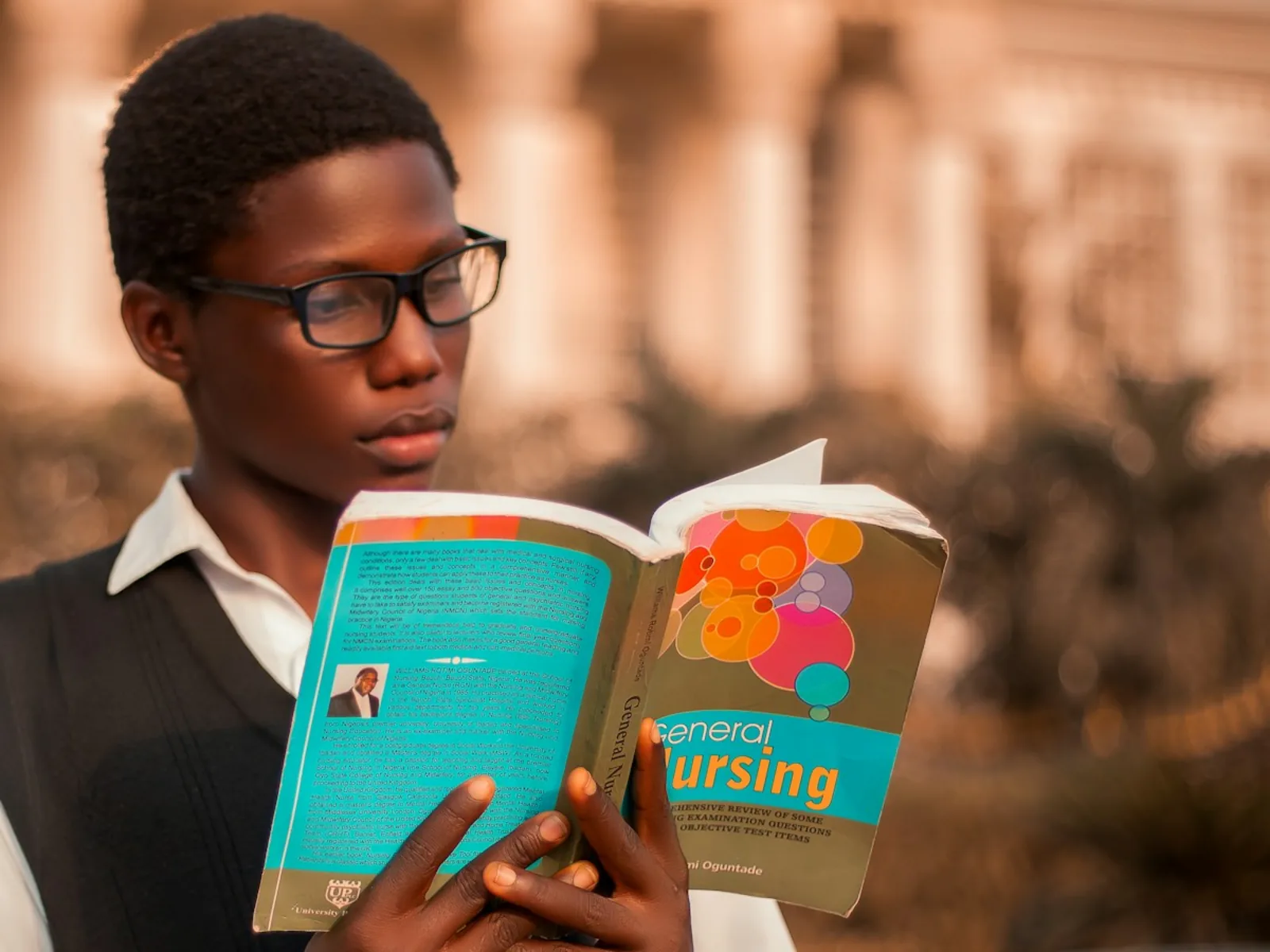 A student reading outside a university building